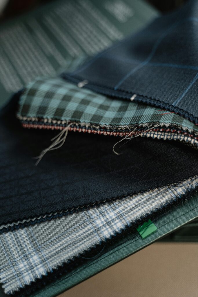 High-quality fabric swatches in various patterns for custom tailoring.